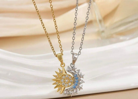 Two necklaces with sun and moon pendants on a white surface